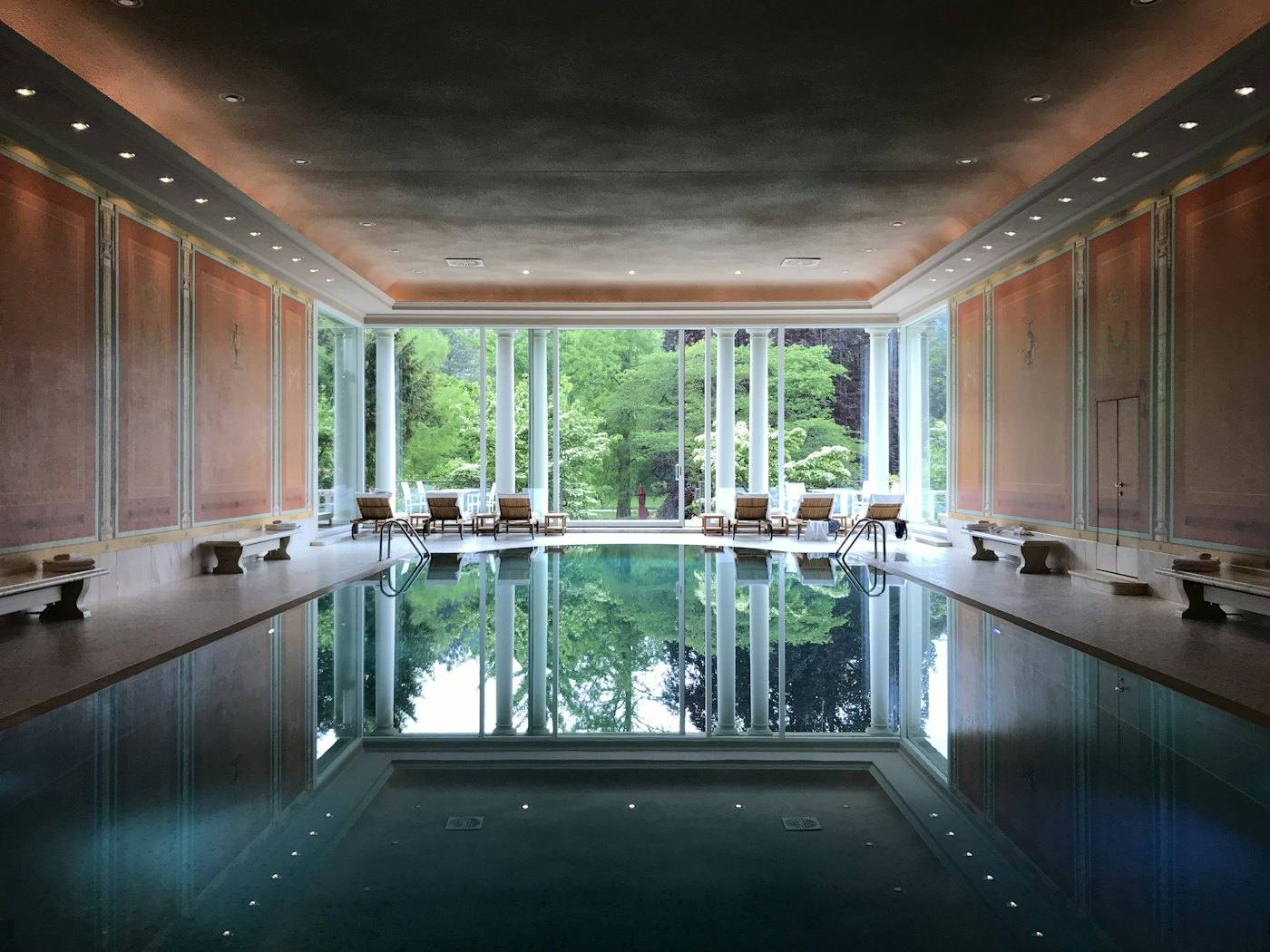 A classic indoor pool with a glass wall to the park