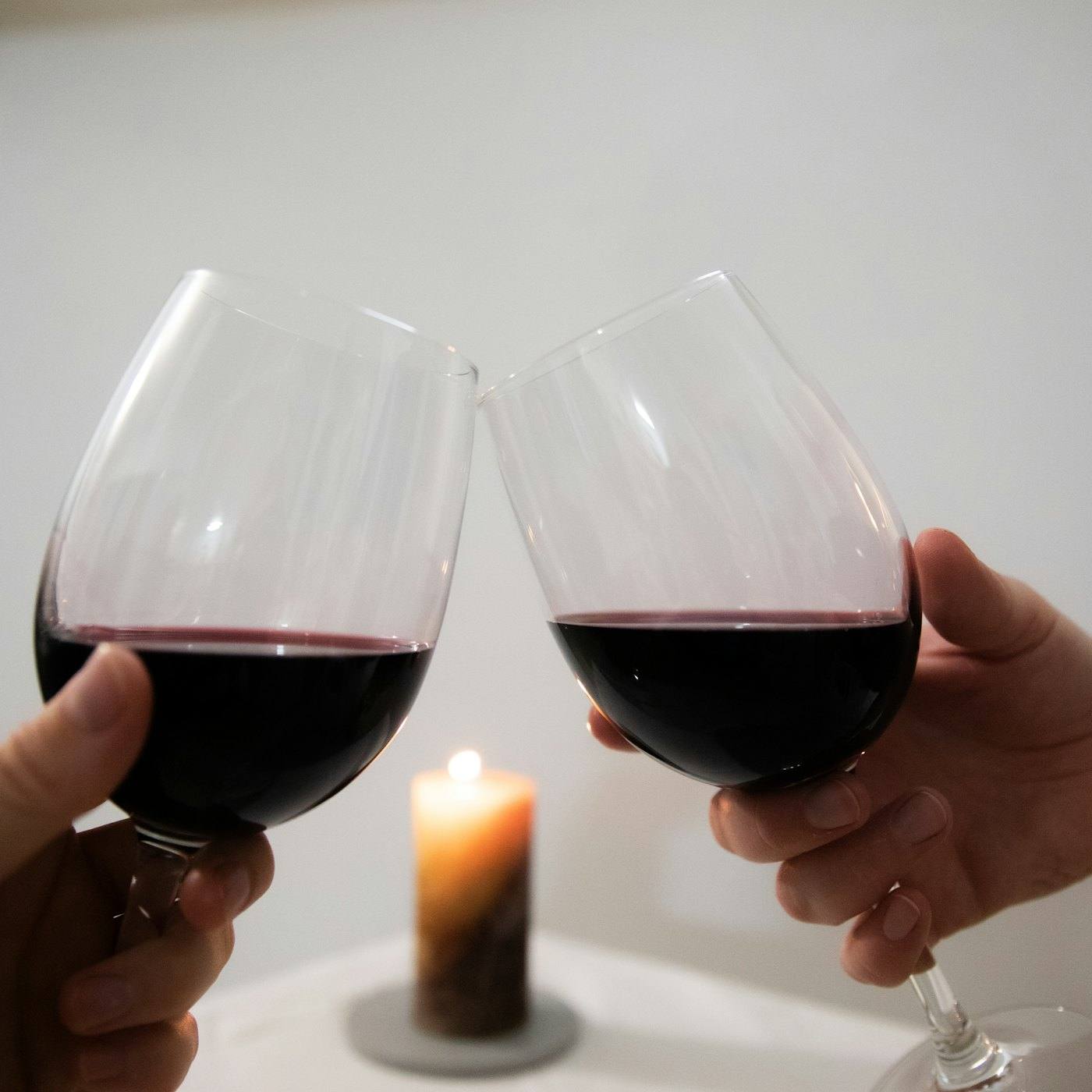 Two glasses of red wine by candlelight
